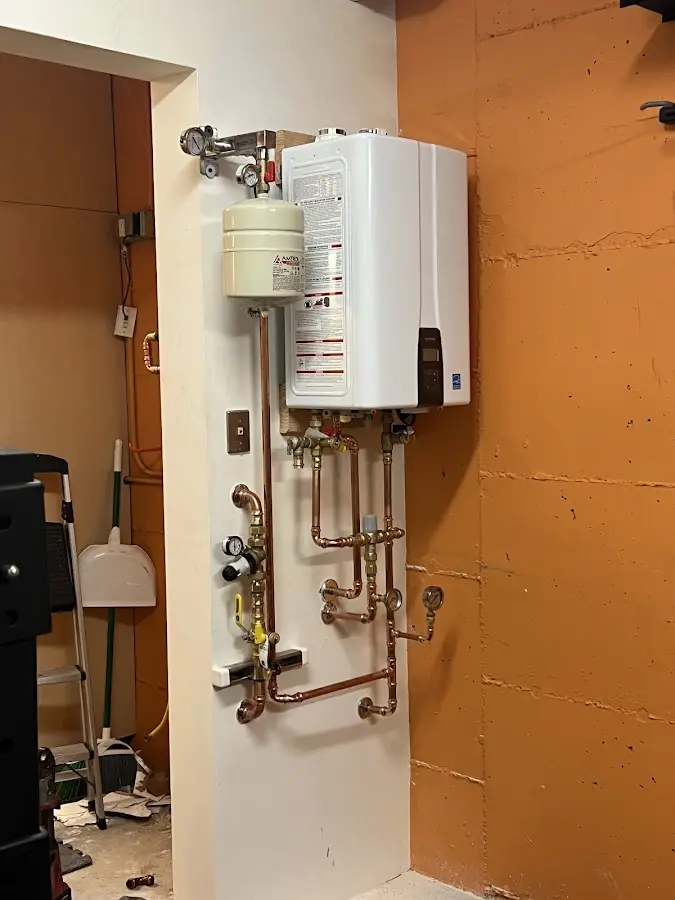 Plumbing technician inspecting water heater connections in Cherry Hill